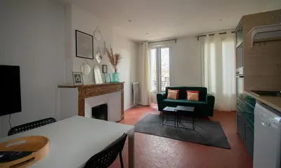 a living room with a couch and a fireplace at Cosy et lumineux - hyper centre - wifi in Aix-en-Provence