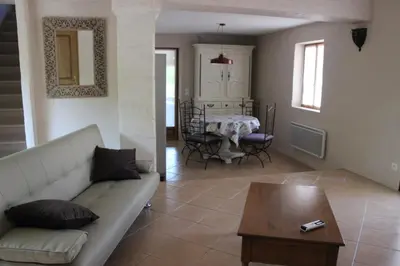 a living room with a couch and a table at Le Gîte du Hameau Fleur de Pierres in Gordes