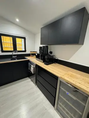 a kitchen with wooden counter tops and black cabinets at La maison vauclusienne in Carpentras