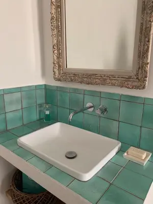 a white sink in a bathroom with a mirror at Les Noyers in Montjustin
