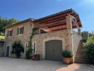 a large brick house with a garage and stairs at Les Noyers in Montjustin