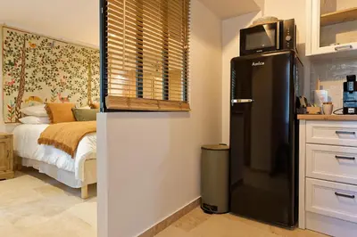a kitchen with a refrigerator next to a bed at Maison Paulette in Eygalières