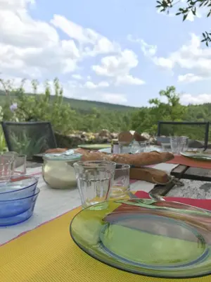 a table with plates and glasses on top of it at Le Mas de Loume in Sault-de-Vaucluse