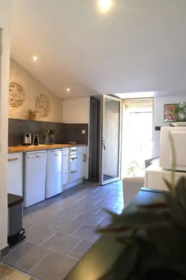 a kitchen with white cabinets and a tile floor at Le Mas de Loume in Sault-de-Vaucluse