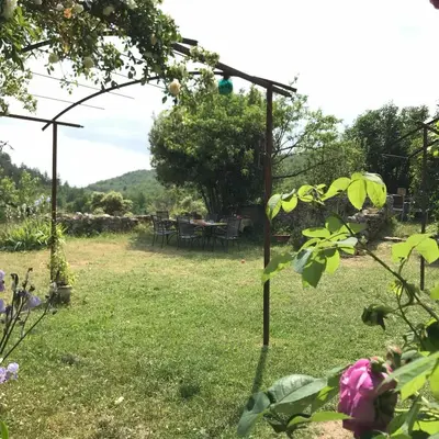 a garden with a table and chairs in the background at Le Mas de Loume in Sault-de-Vaucluse