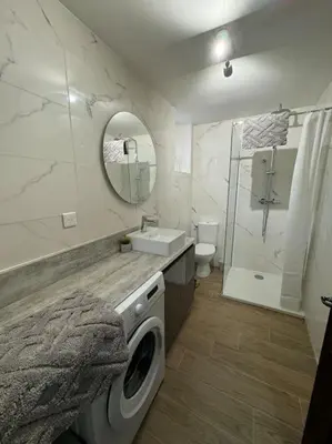 a bathroom with a sink and a washing machine at Appartement T2 Cosy centre-ville in Pernes-les-Fontaines