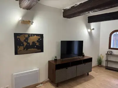 a living room with a flat screen tv on a wall at Appartement T2 Cosy centre-ville in Pernes-les-Fontaines