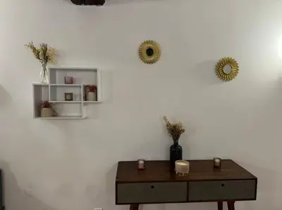 a table with two mirrors on a white wall at Appartement T2 Cosy centre-ville in Pernes-les-Fontaines