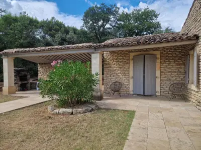 a brick house with a patio with two chairs at Villa Trempadou in Gordes