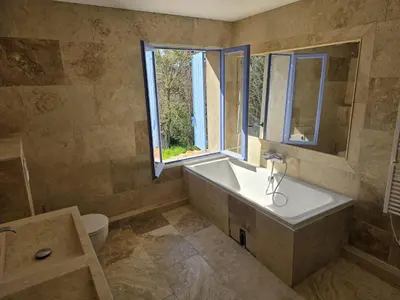 a bedroom with a bed and a dresser and a lamp at Bastide Hedone en Luberon in Apt
