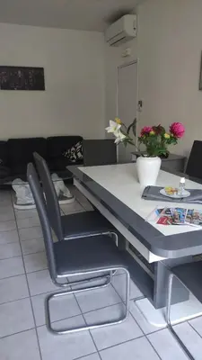 a dining table and chairs in a living room at L'Appart in Cheval-Blanc