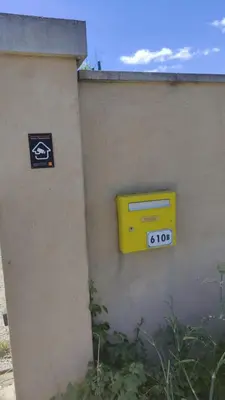 a yellow mailbox on the side of a wall at L'Appart in Cheval-Blanc