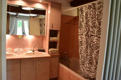 a bathroom with a sink and a shower curtain at La Chambre des Amis au Moulin des GYPSES, Ventoux in Mormoiron