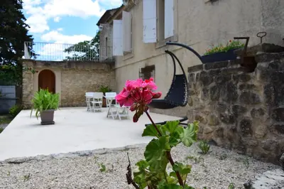 a pink flower in front of a building at La Chambre des Amis au Moulin des GYPSES, Ventoux in Mormoiron