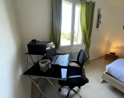 a desk with a computer and a chair in a bedroom at Le petit paradis au cœur du Luberon in Saint-Saturnin-les-Apt
