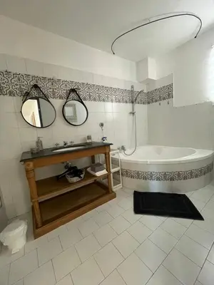 a bathroom with a tub and a sink and a mirror at A l'ombre des oliviers in LʼIsle-sur-la-Sorgue