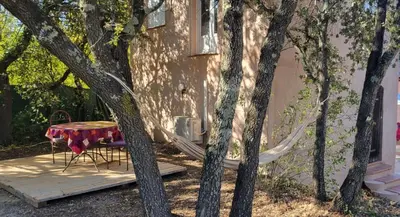 a table and chairs sitting on a deck next to a house at Mazet in Rognes