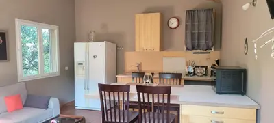 a kitchen with a counter with chairs and a refrigerator at Mazet in Rognes