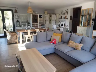a living room with a blue couch and a table at Villa moderne avec piscine in Monteux