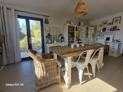 a dining room with a wooden table and chairs at Villa moderne avec piscine in Monteux
