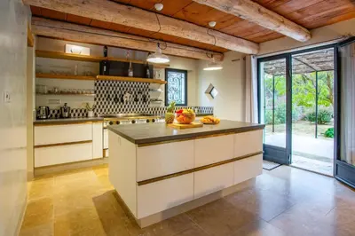 a kitchen with white cabinets and a large island at Villa Les Alpilles by Villa Plus in Mouriès