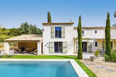 a villa with a swimming pool in front of a house at Villa Les Alpilles by Villa Plus in Mouriès