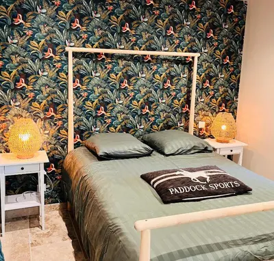 a bedroom with a bed with a floral wallpaper at Évasion charme et jacuzzi en pleine nature in Grans