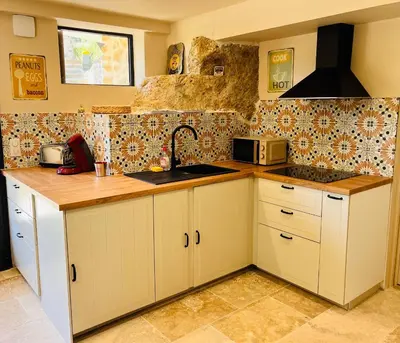 a kitchen with white cabinets and a sink at Évasion charme et jacuzzi en pleine nature in Grans