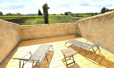 a patio with two chairs and a bench and a table at Maison provençale au milieu des champs in Robion en Luberon