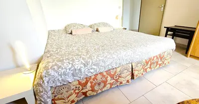 a bedroom with a bed with a white comforter at Maison provençale au milieu des champs in Robion en Luberon