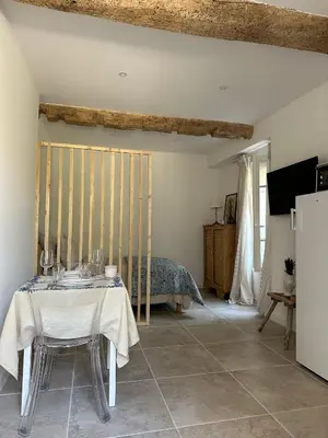 a dining room with a table and a bed at Studio centre ville la Toscane in LʼIsle-sur-la-Sorgue