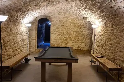 a room with a ping pong table and two benches at Village home in Ménerbes in Ménerbes