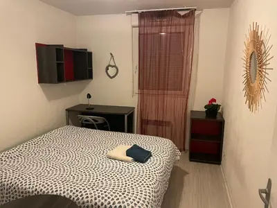 a bedroom with a bed and a desk and a television at Joli appartement sur Aix-en-Provence in Aix-en-Provence