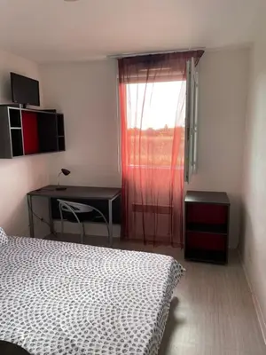 a bedroom with a bed and a desk and a window at Joli appartement sur Aix-en-Provence in Aix-en-Provence
