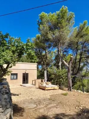 a house with a tree and a couch in a yard at Gîte en Provence pour amoureux de la nature in Rognes