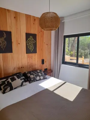 a bedroom with a bed with a wooden wall at Gîte en Provence pour amoureux de la nature in Rognes