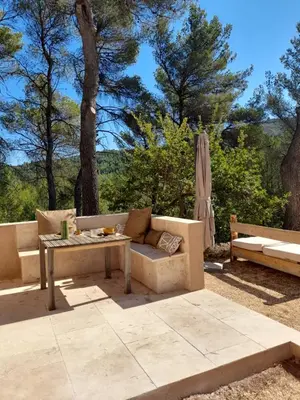 a patio with a couch and a table at Gîte en Provence pour amoureux de la nature in Rognes