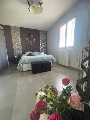 a bedroom with a bed and flowers on the floor at Chaleureuse maison in Cavaillon