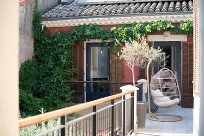 a balcony with a chair and ivy on a building at La Maison Clémenceau in Salon-de-Provence