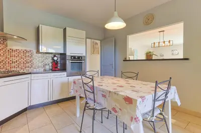a kitchen with a table and chairs in a room at Source de Vie in Noves