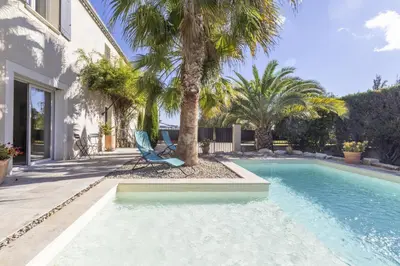 a swimming pool with a chair next to a house at Source de Vie in Noves