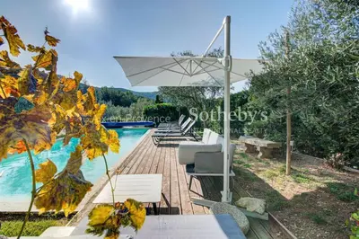 a pool with a table and chairs and an umbrella at Domaine entier au havre de paix 4 chambres in Vauvenargues
