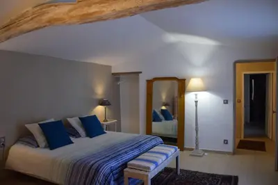 a bedroom with a large bed with blue pillows at Moulin des Gypses Gîte Les Pampres, Ventoux in Mormoiron
