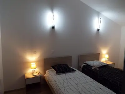 two beds in a room with two lights on the wall at Appartement charmant près du centre d'Avignon, 60m², piscine in Avignon