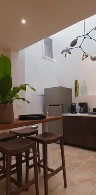 a kitchen with a table and two stools in a room at Cycle , Cook and Relax in Caromb
