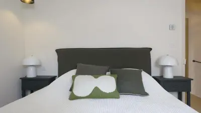 a bedroom with a bed with two night stands and two lamps at Cycle , Cook and Relax in Caromb