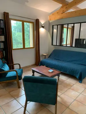 a bedroom with a bed and a table and a chair at Maison du vallon de Galeye in La Roque-sur-Pernes