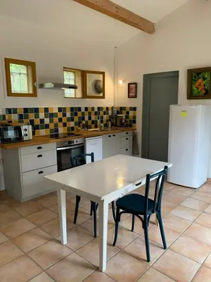 a kitchen with a white table and two chairs at Maison du vallon de Galeye in La Roque-sur-Pernes