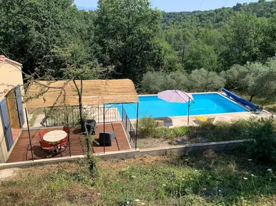 a swimming pool with a deck and an umbrella at Maison du vallon de Galeye in La Roque-sur-Pernes