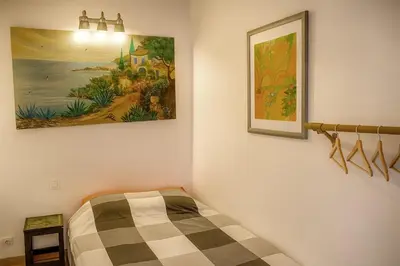 a bedroom with a bed and a painting on the wall at Le Cabanon Provençal Traditionnel Jardin Barbecue & Cheminée in Saumane-de-Vaucluse